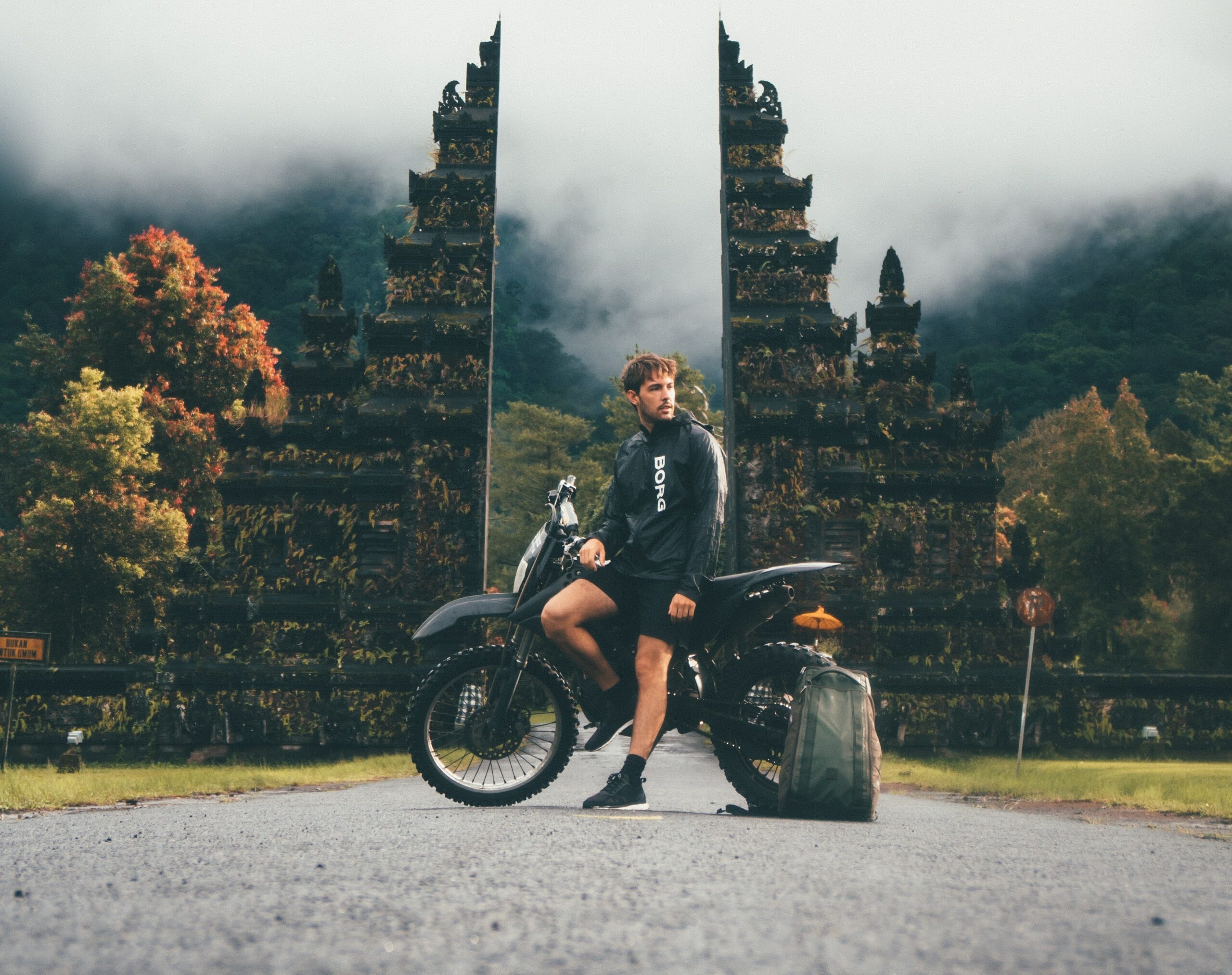男人与一辆摩托车和一个背包