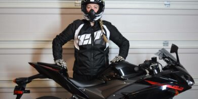 图标女子Automag 2夹克穿的布列塔尼在她旁边的摩托车