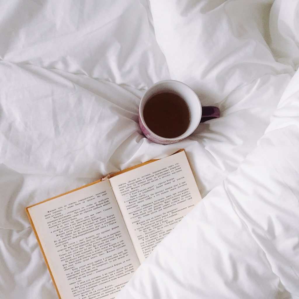 书和咖啡杯在床上