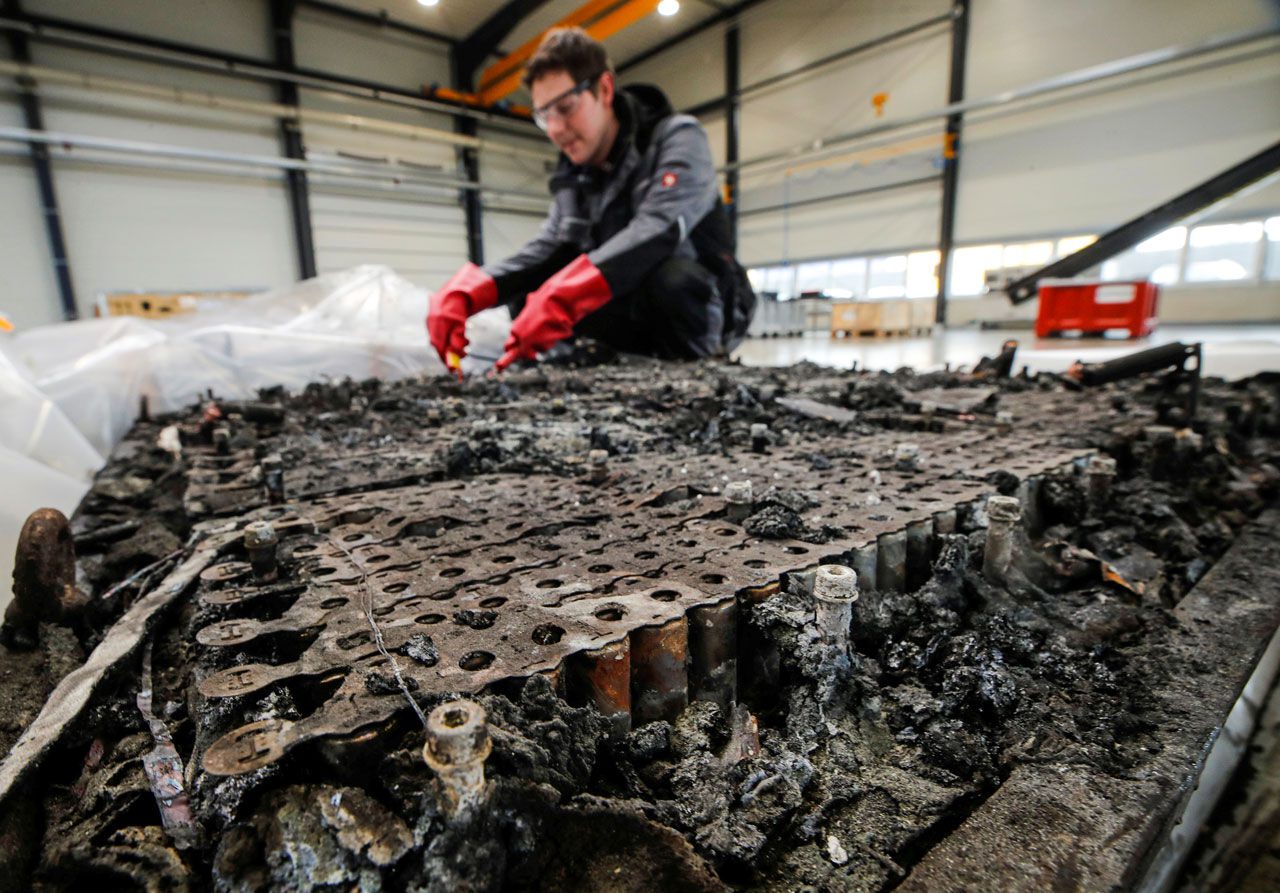 技师检查的剩余电压烧毁的汽车锂离子电池拆除前由德国回收公司在Krefeld Accurec