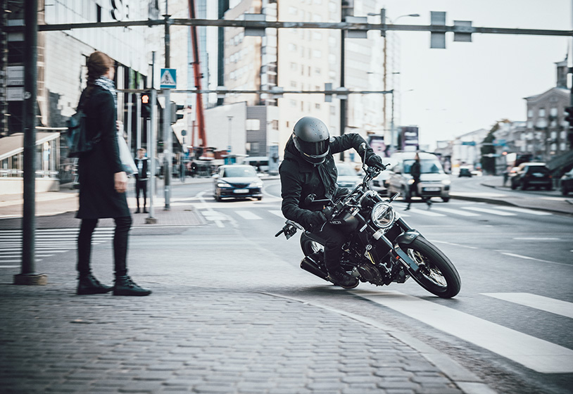 一名骑在新款2021 Husqvarna Svartpilen 401上的骑手，在城镇的十字路口转弯。