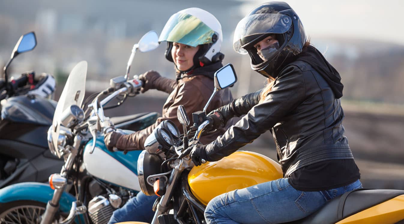 女骑摩托车的人骑在一起的照片