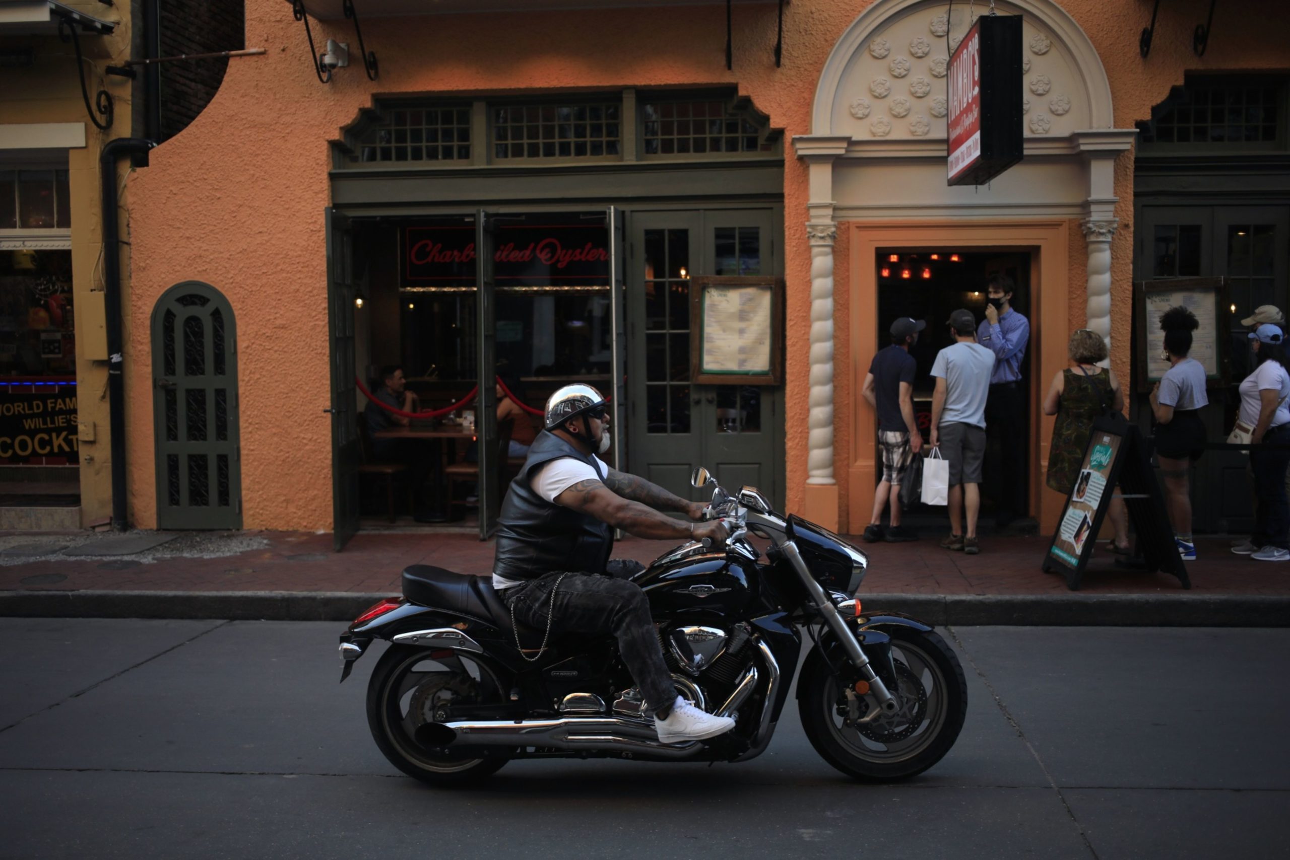 2021年4月20日(星期二)，在美国路易斯安那州新奥尔良的法国区波旁街，一名男子骑着摩托车从排队进入餐厅的顾客面前经过。兰格研究公司将于4月22日发布消费者舒适度数据。摄影师:Luke Sharrett/Bloomberg