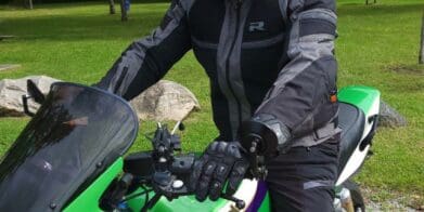 男人穿理查德Airstorm WP夹克坐在绿色的川崎摩托车