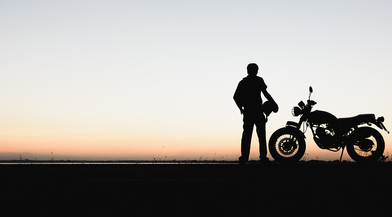 骑摩托车的人欣赏日落的剪影