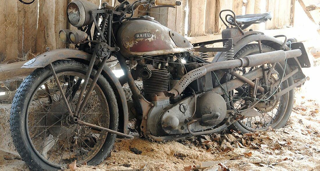 一辆老式的艾瑞尔摩托车停在谷仓里等待修理