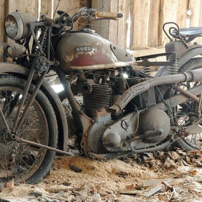 一辆旧的阿里尔摩托车停在谷仓里等待修理
