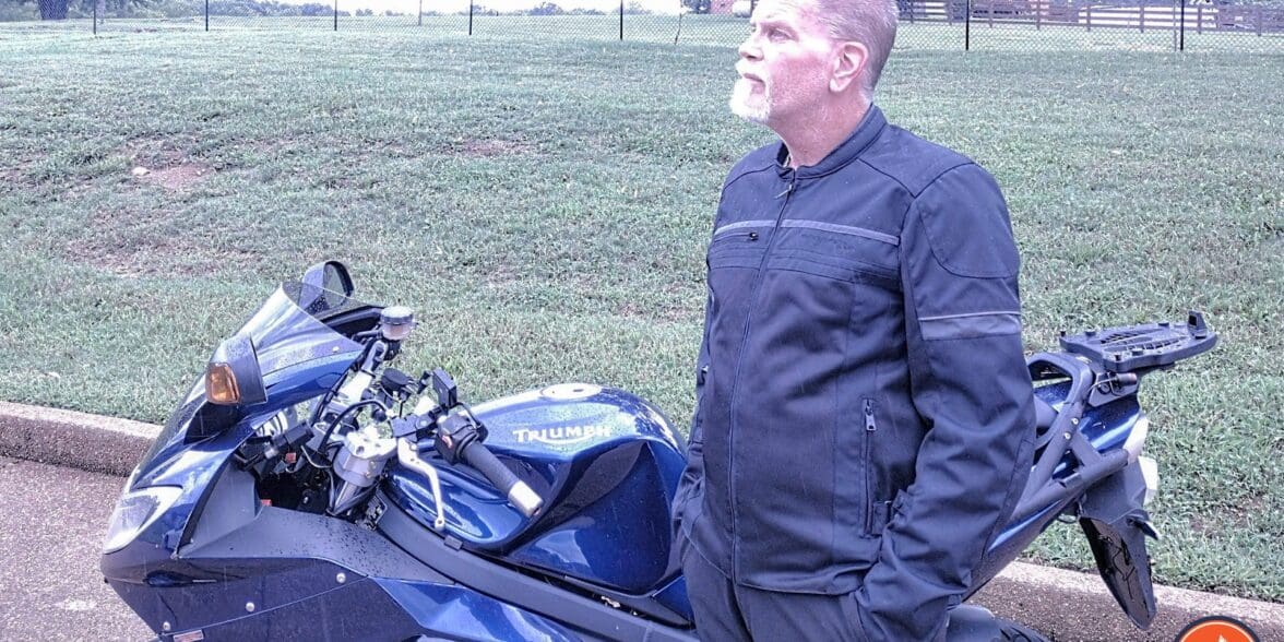 作者穿着蝎子货运空气夹克旁边凯旋摩托车