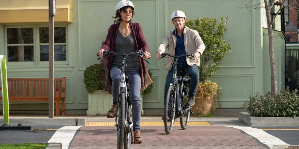 两个穿着随意车手,一个男人和一个女人,在自行车道上eBikes。18luck新利娱乐在线