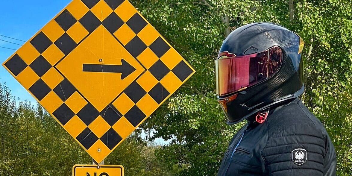 作者戴着Icon Airframe Pro碳头盔，站在路标旁边