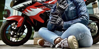 作者盘腿坐在前面的摩托车穿着赛车美国女性的维修站手套