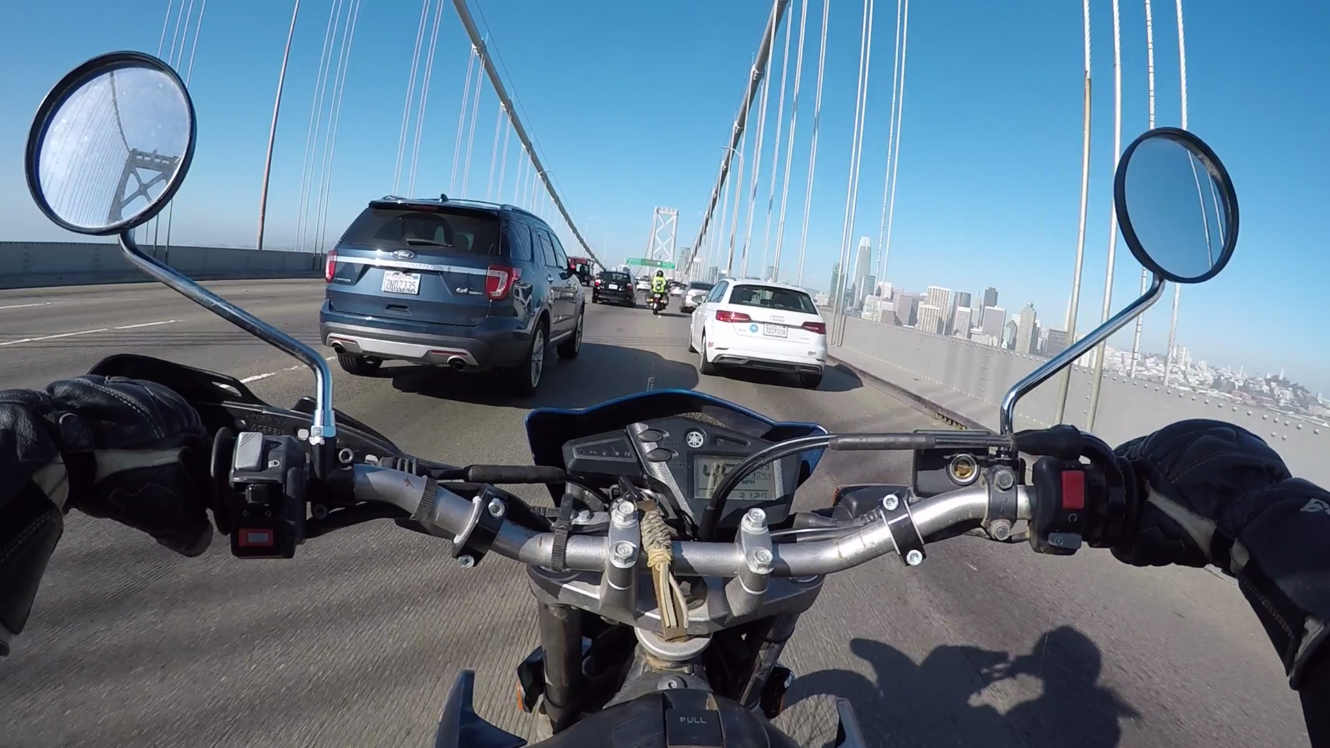 一个骑摩托车的人在交通拥挤的桥上